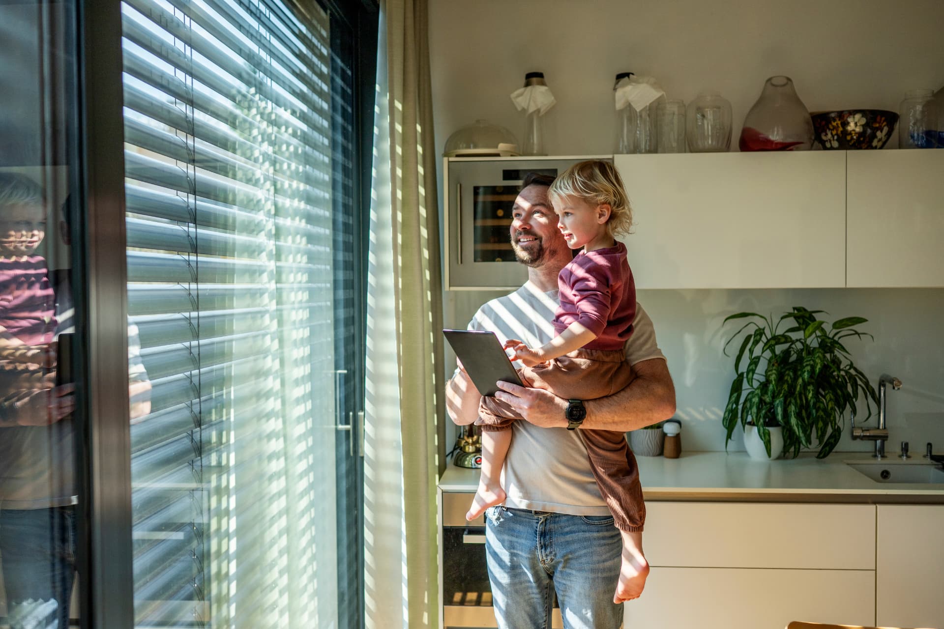 Parent and child looking out a window at home