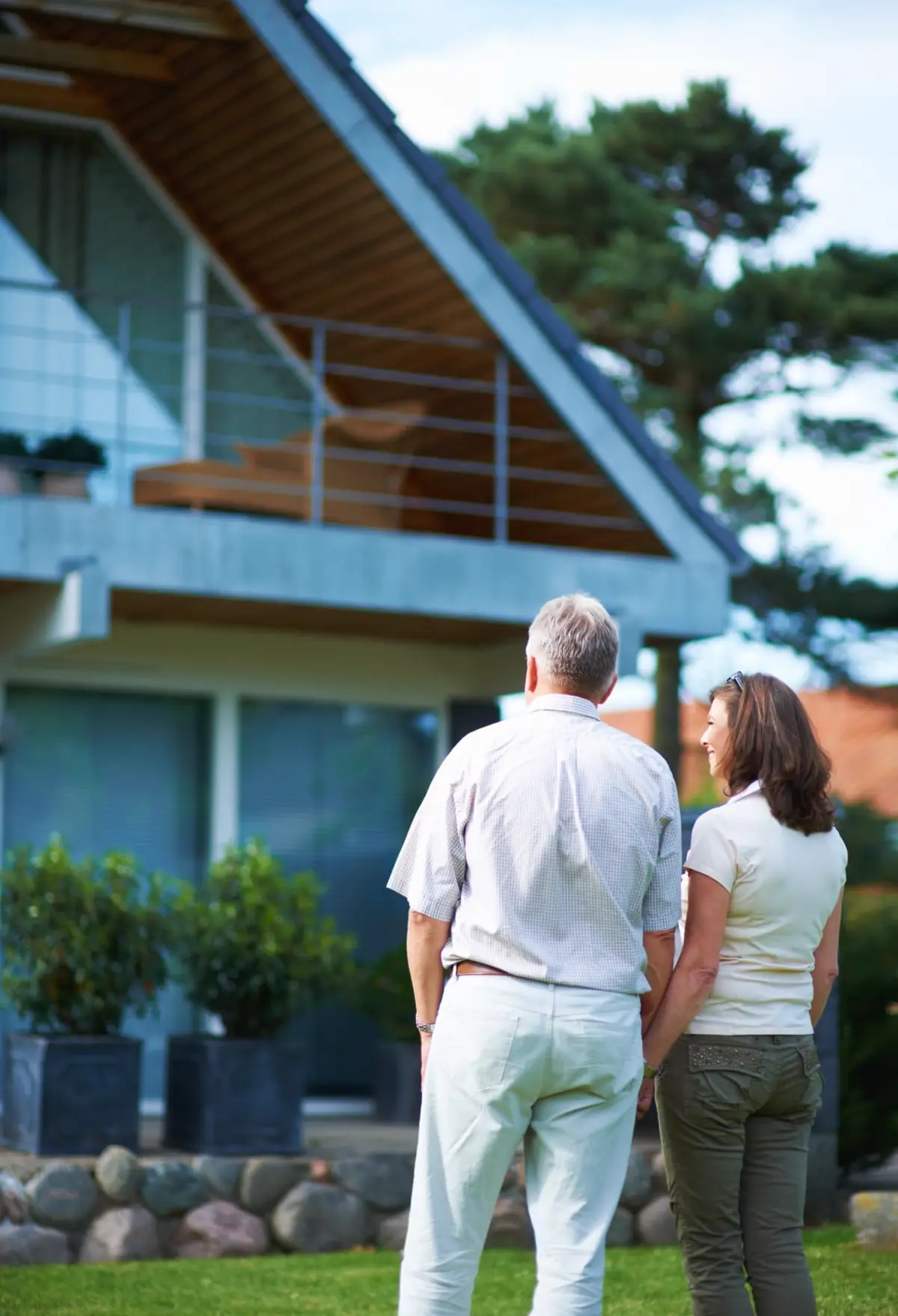 Homeowners looking at the roof of their two-story house before ordering a RooFax roof inspection report