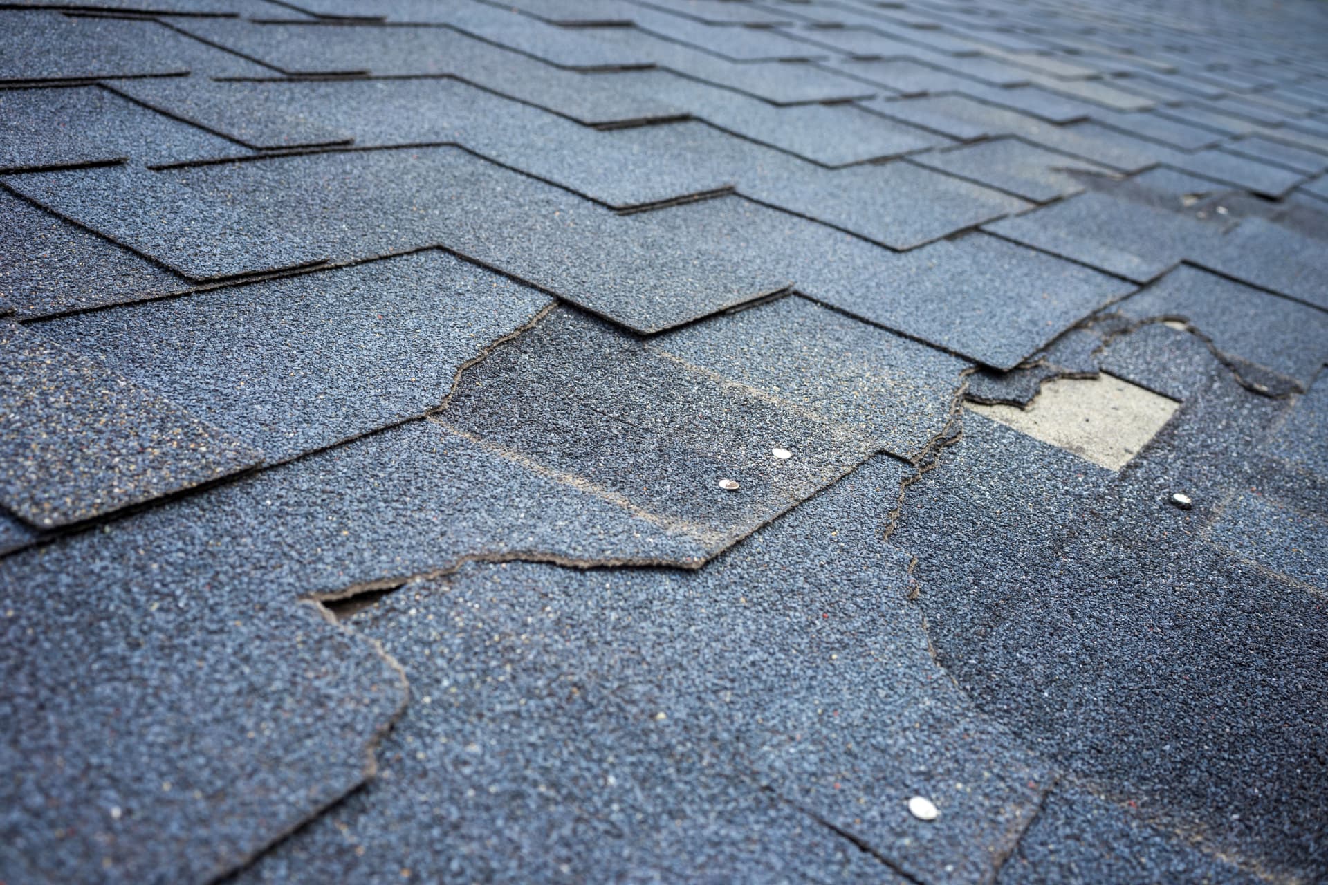 Damaged and missing shingles on a residential roof